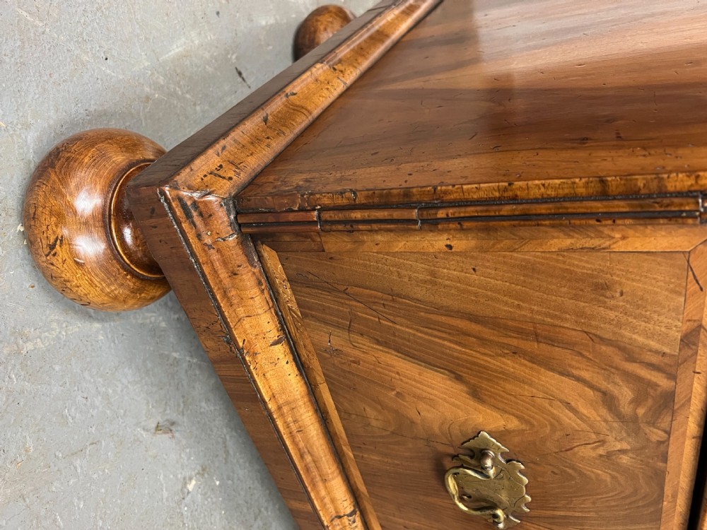 A William and Mary figured walnut escritoire featuring a double-dome arched pediment, a fall-front writing surface concealing a multi-drawer fitted interior, and a chest base on turned bun feet. View VIII