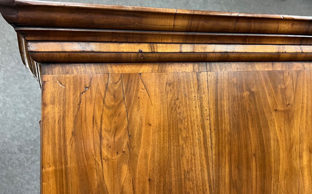 A William and Mary figured walnut escritoire featuring a double-dome arched pediment, a fall-front writing surface concealing a multi-drawer fitted interior, and a chest base on turned bun feet. View XIV