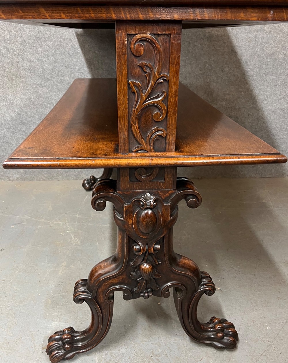 A dark oak Victorian rise and fall three-tiered dumb waiter with carved foliage borders and ornate leg supports. View III