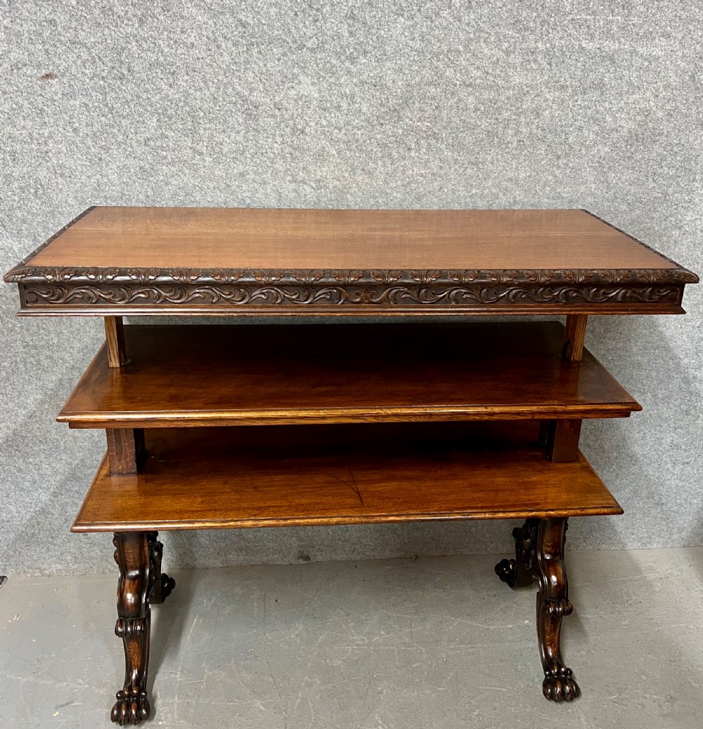 A dark oak Victorian rise and fall three-tiered dumb waiter with carved foliage borders and ornate leg supports. View IV
