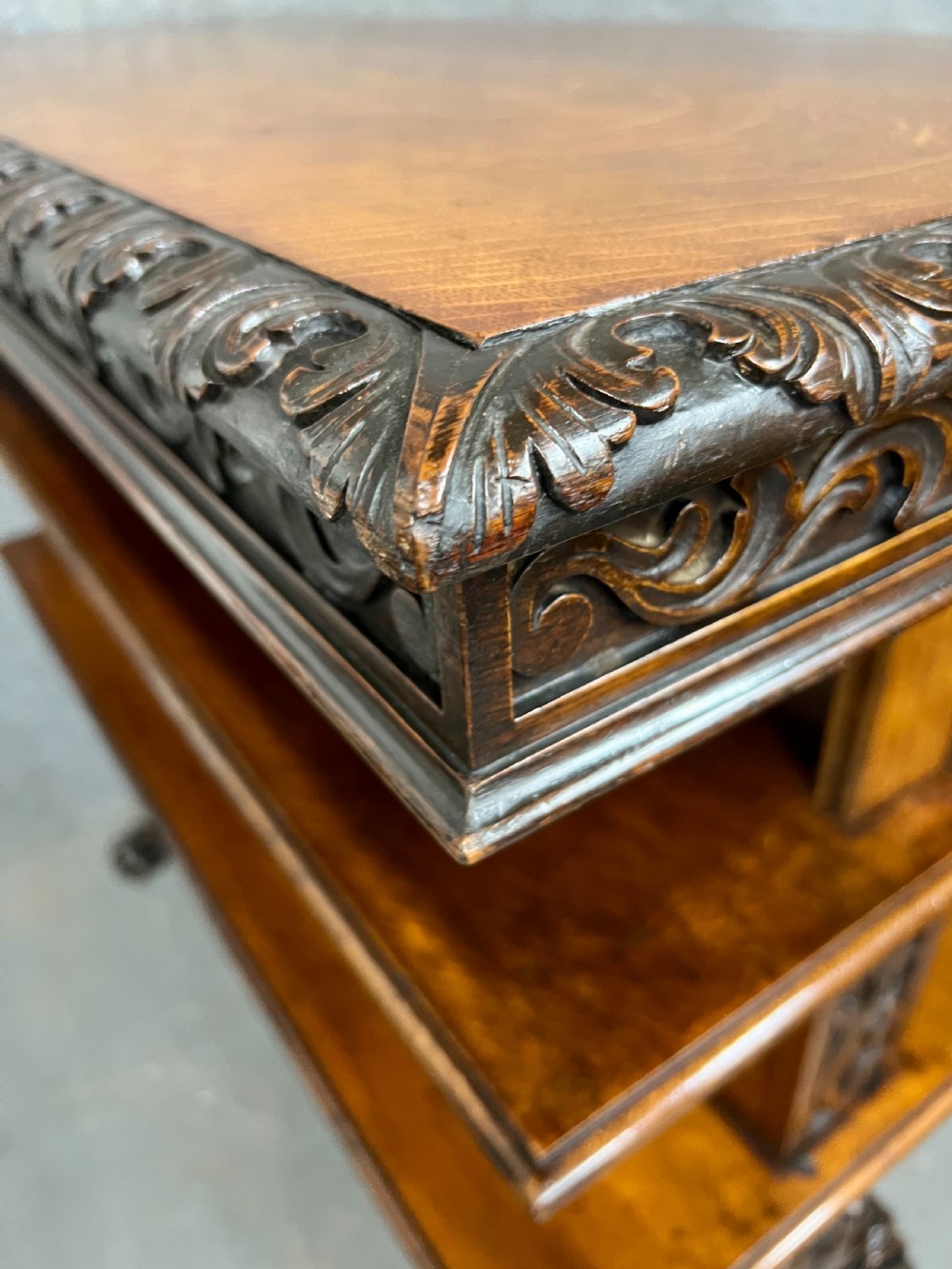 A dark oak Victorian rise and fall three-tiered dumb waiter with carved foliage borders and ornate leg supports. View V