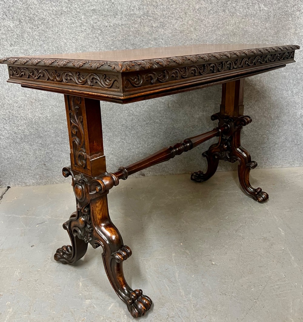 A dark oak Victorian rise and fall three-tiered dumb waiter with carved foliage borders and ornate leg supports. View VII