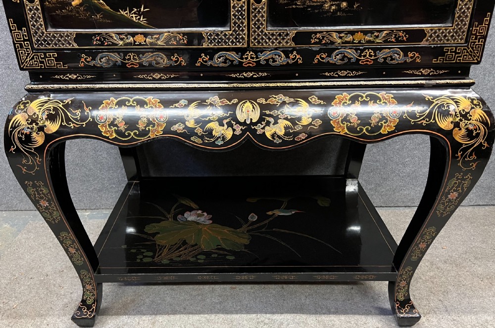 A black lacquered Chinoiserie cocktail cabinet on stand featuring hand-painted botanical motifs, birds, figures, and gilt cabriole legs. View IV