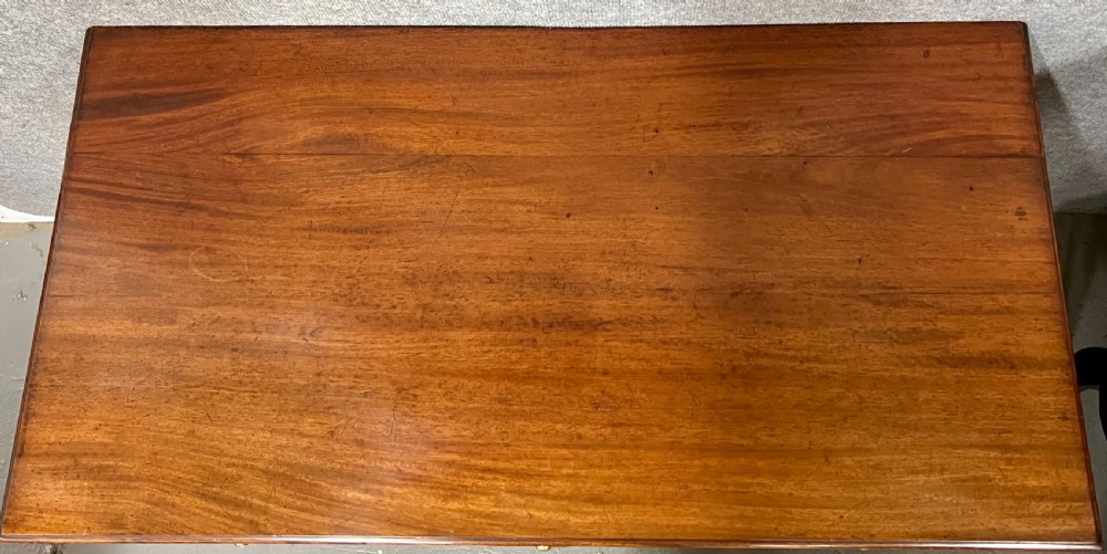 A small Georgian mahogany sideboard featuring three drawers with circular veneered panels, brass ring handles, and four square tapered legs. View VII