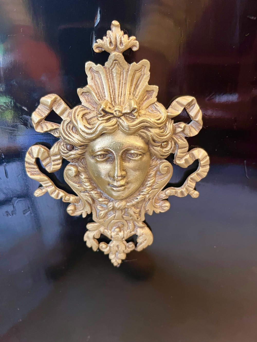 An ebonised two-door display cabinet featuring glass panels, detailed gilt bronze ormolu mounts, cherub term figures, and ornamental friezes. View VII