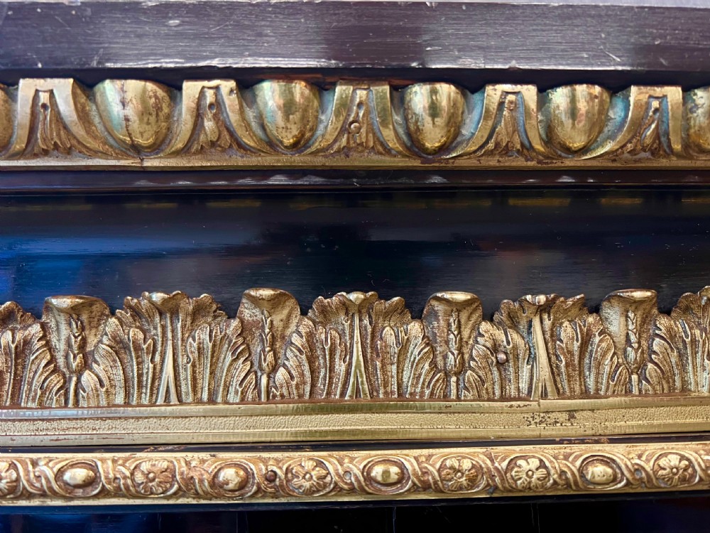 An ebonised two-door display cabinet featuring glass panels, detailed gilt bronze ormolu mounts, cherub term figures, and ornamental friezes. View XI