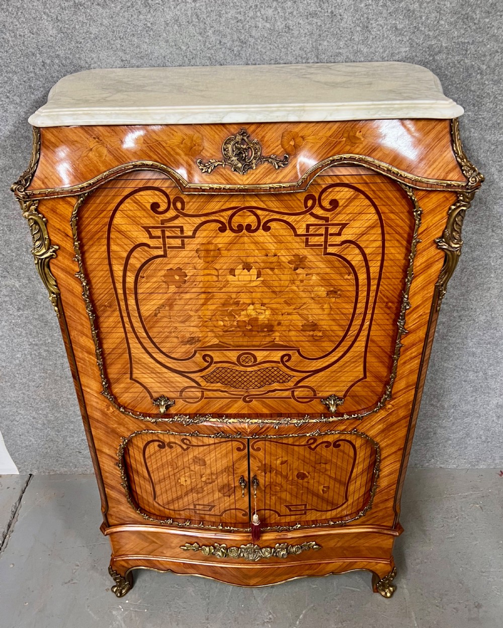 A French Louis XV style kingwood cocktail cabinet featuring floral marquetry inlays, ornate bronze mounts, and a marble top. View V