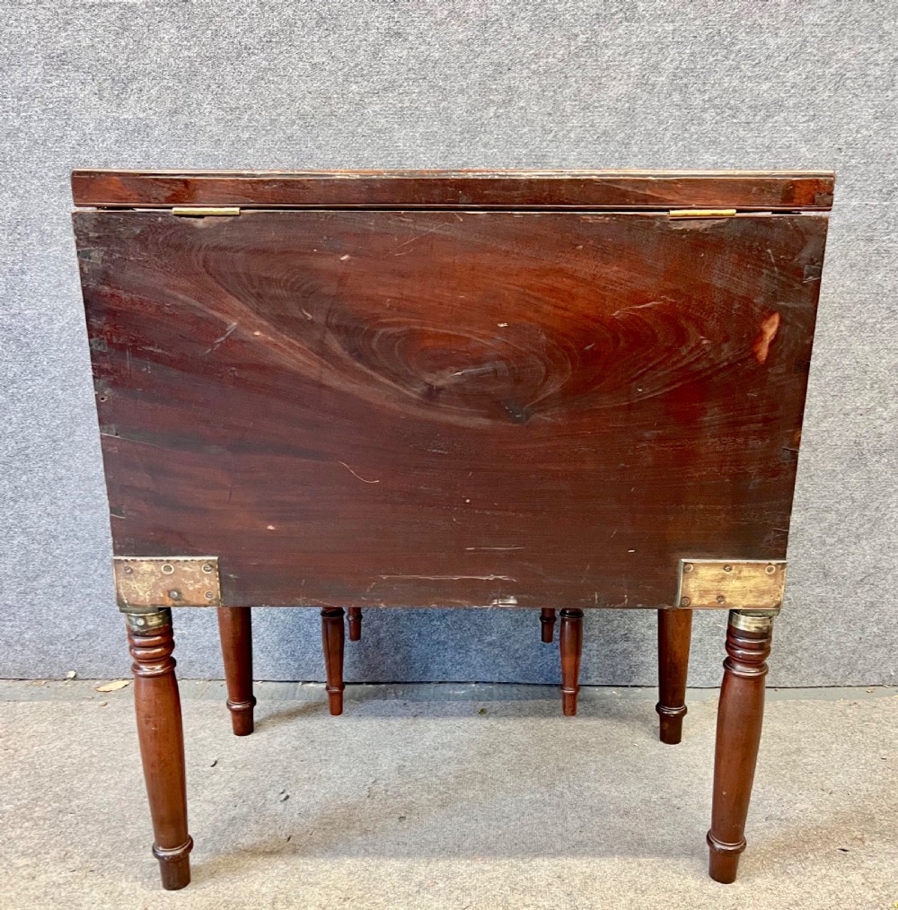 A George III mahogany campaign dressing chest featuring a hinged top revealing an adjustable mirror, brass corner mounts, flush handles, and turned legs. View IX