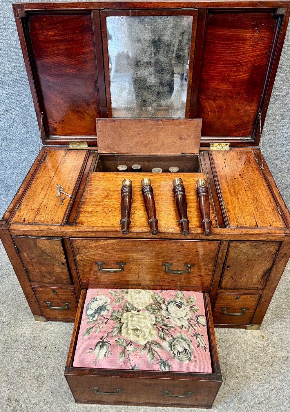 A George III mahogany campaign dressing chest featuring a hinged top revealing an adjustable mirror, brass corner mounts, flush handles, and turned legs. View XII