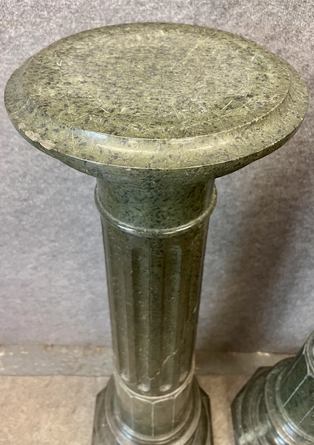 A pair of 19th-century carved dark green serpentine marble columns featuring fluted shafts, moulded capitals, and stepped octagonal bases. View IX