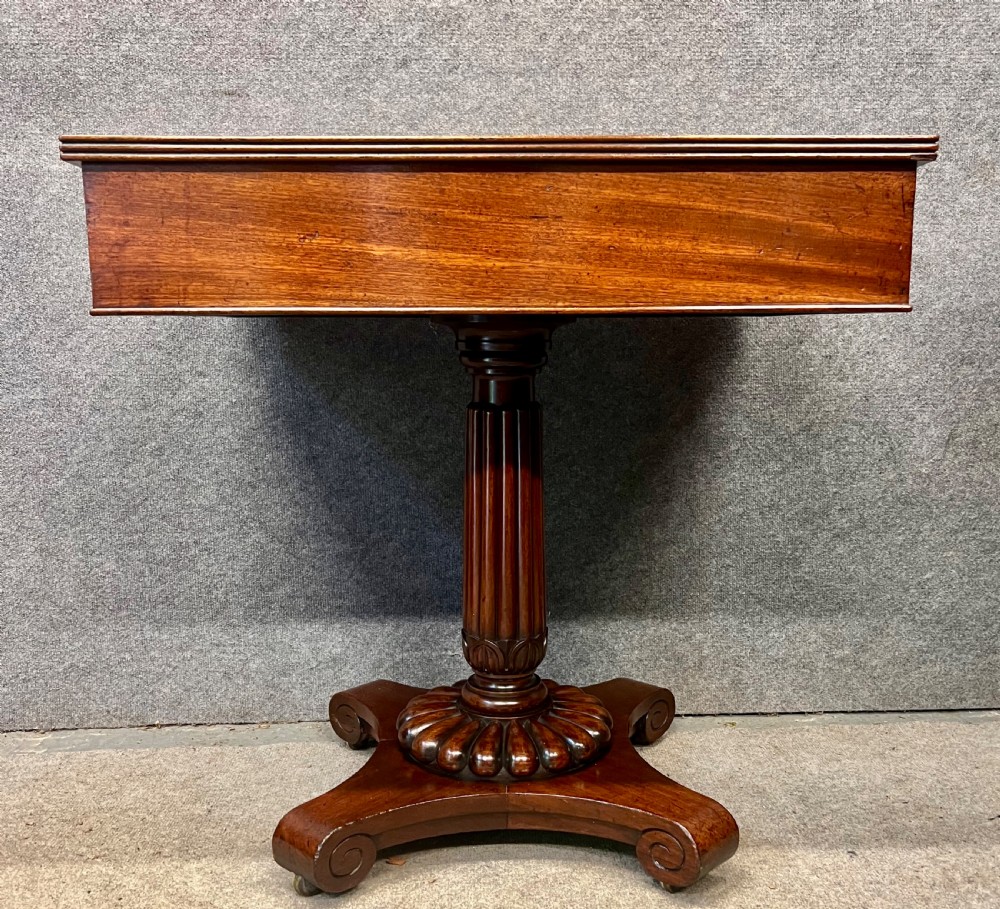 Antique William IV mahogany occasional table with two drawers, a reeded pedestal stem, and a scroll-foot base on brass castors. View V