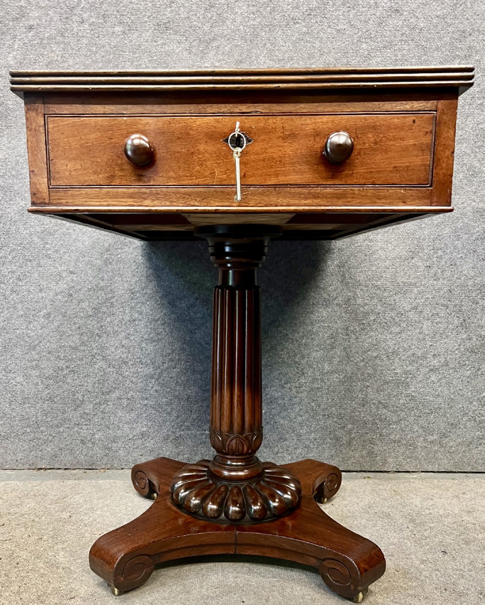 Antique William IV mahogany occasional table with two drawers, a reeded pedestal stem, and a scroll-foot base on brass castors. View VI