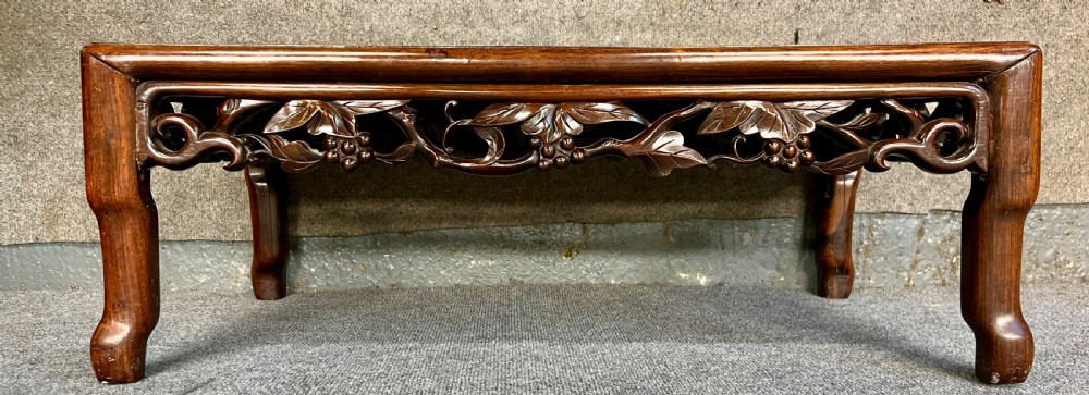 A matched pair of rectangular Chinese low hardwood tables with intricately carved openwork floral aprons and curved legs. View III
