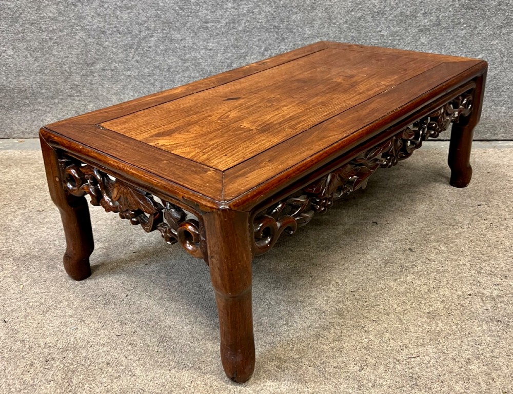 A matched pair of rectangular Chinese low hardwood tables with intricately carved openwork floral aprons and curved legs. View IV