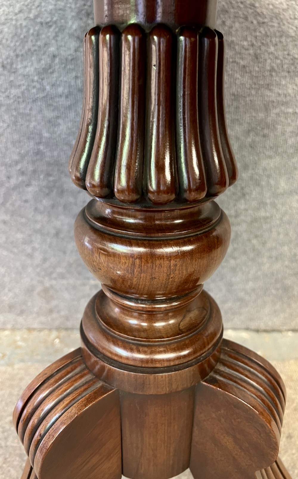 A Regency mahogany two-tier table with circular dished surfaces, a central reeded column, and a tripod base on brass castors. View V