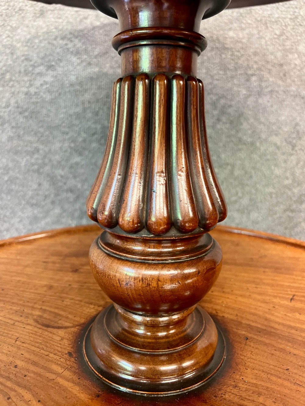 A Regency mahogany two-tier table with circular dished surfaces, a central reeded column, and a tripod base on brass castors. View VI