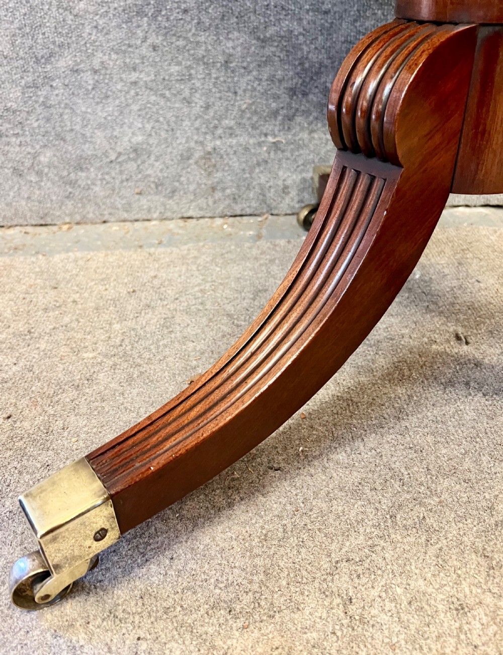 A Regency mahogany two-tier table with circular dished surfaces, a central reeded column, and a tripod base on brass castors. View VII