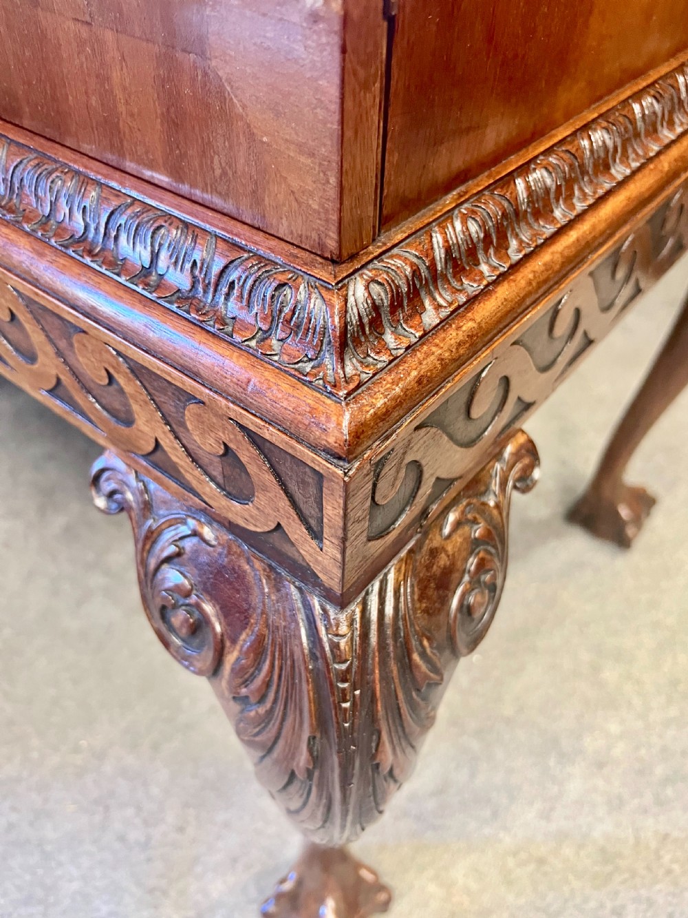 An open Edwardian mahogany folio cabinet featuring twin doors, internal sliding trays, carved top moulding, and claw and ball feet. View XI