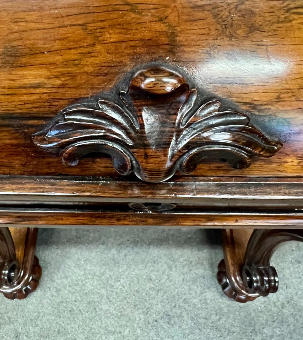 A Victorian rosewood davenport desk with an elevated pop-up stationery gallery, slanted piano top writing slope, side drawers, and carved cabriole support legs. View VI