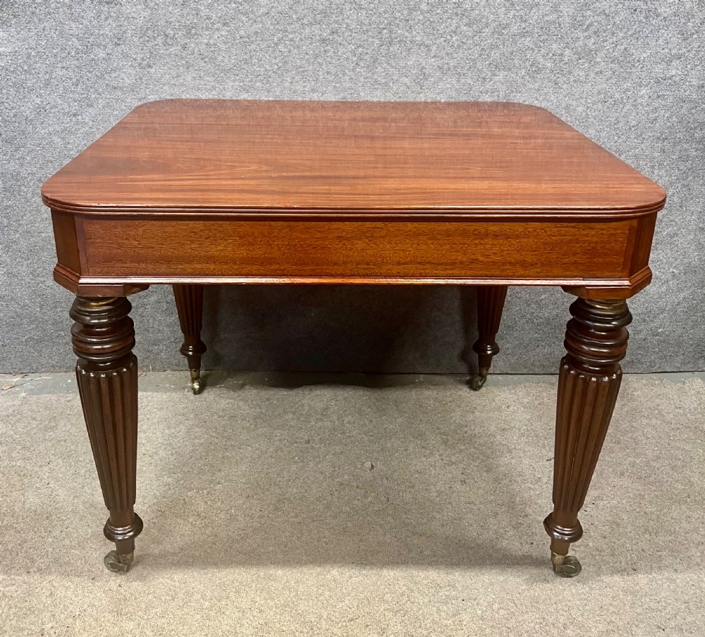 A 19th-century mahogany campaign table featuring turned fluted legs with brass castors and a rectangular polished top. View VIII