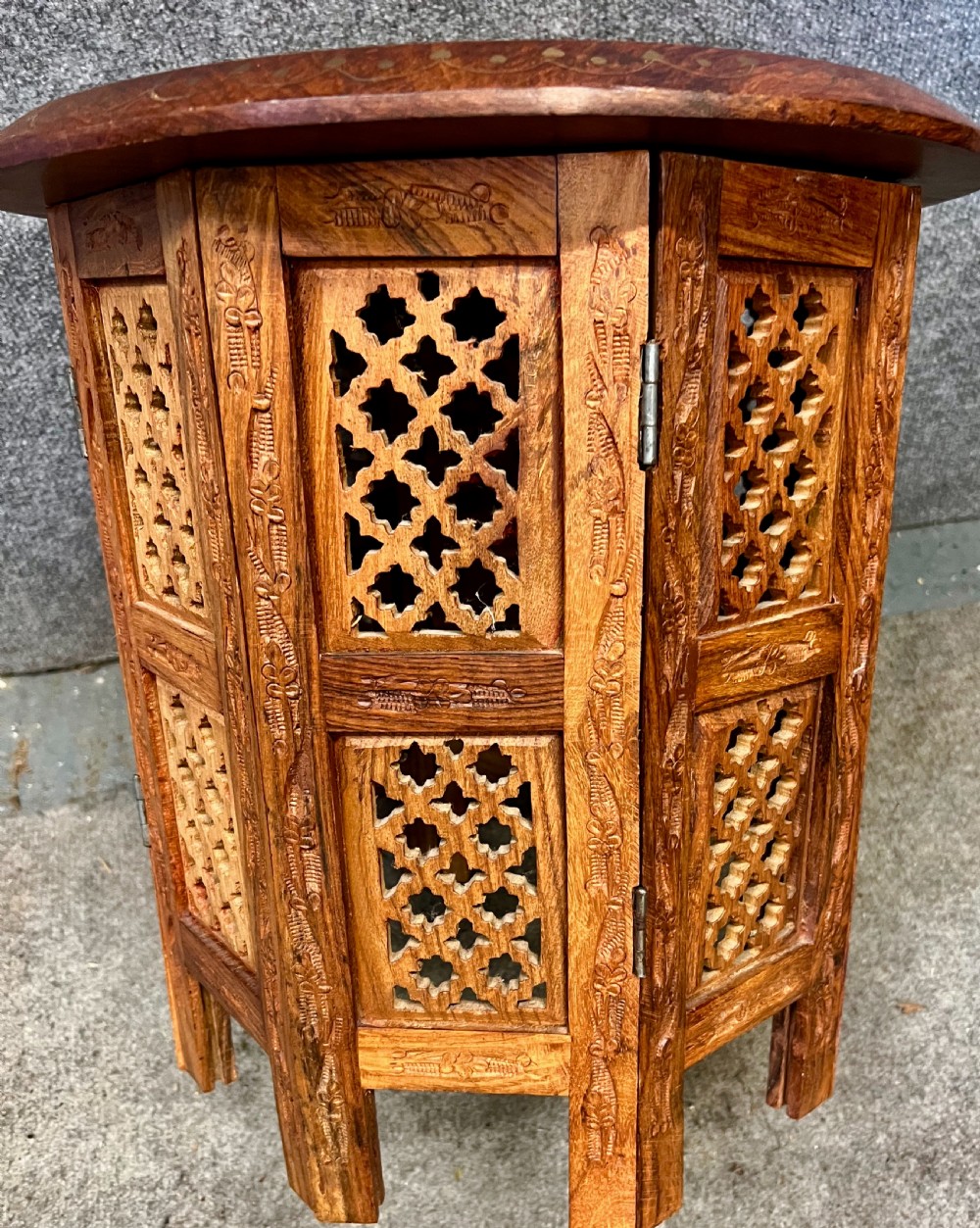 A small octagonal wooden side table featuring floral brass inlay on the top and pierced jali lattice panels on the base. View II