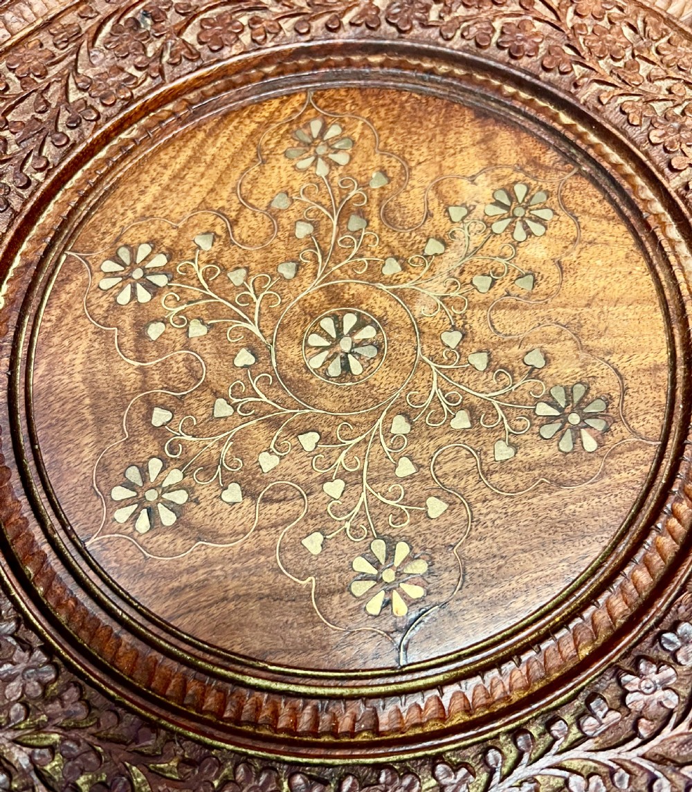 A small octagonal wooden side table featuring floral brass inlay on the top and pierced jali lattice panels on the base. View VI