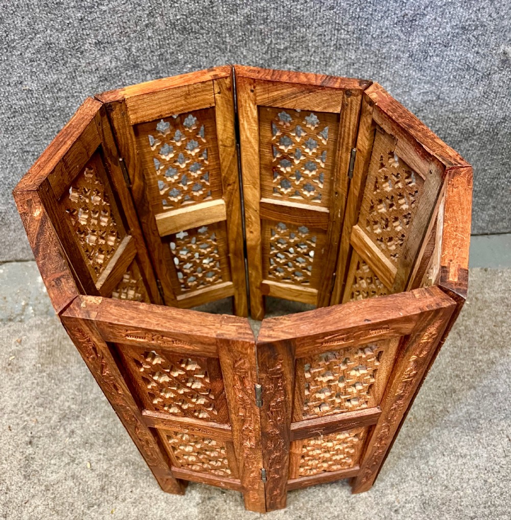 A small octagonal wooden side table featuring floral brass inlay on the top and pierced jali lattice panels on the base. View VII