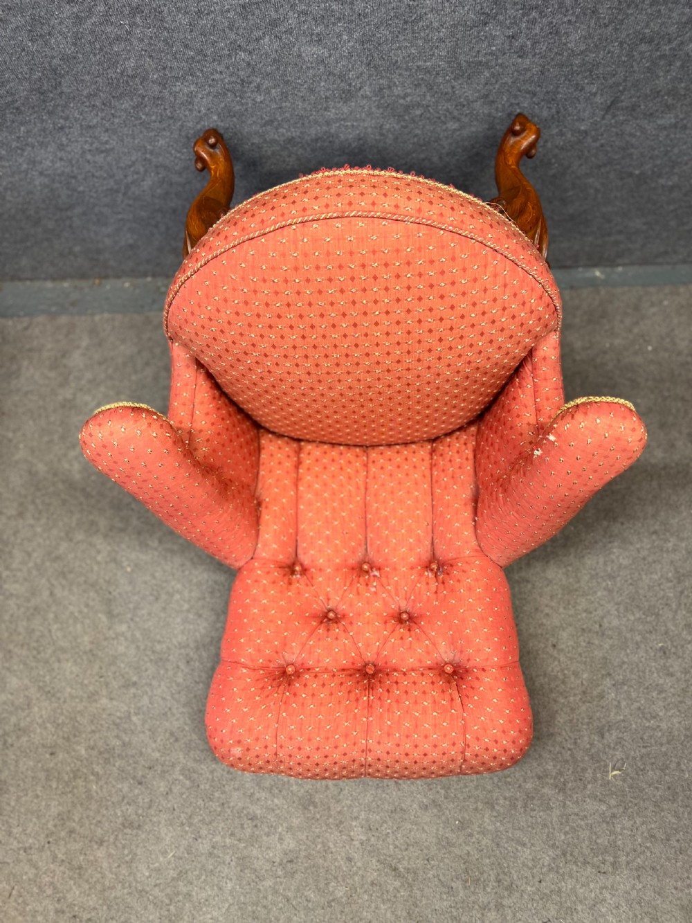A pair of Victorian tub armchairs featuring patterned terracotta fabric, deep button tufting, and carved timber cabriole legs with brass castors. View VII