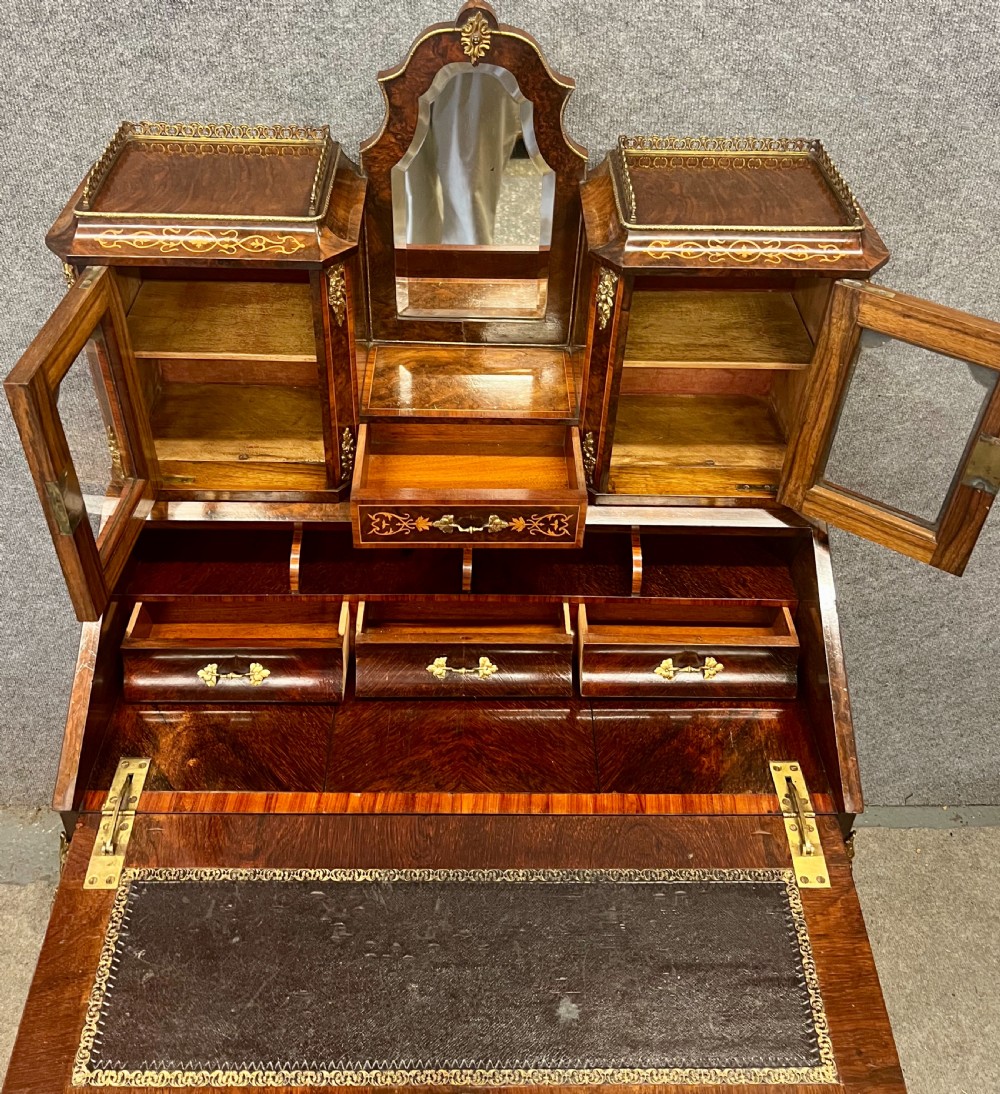 An antique Victorian inlaid walnut bureau de dame featuring a slant-front writing lid, floral marquetry, brass mounts, cabriole legs, and an upper cabinet with glazed doors. View VII