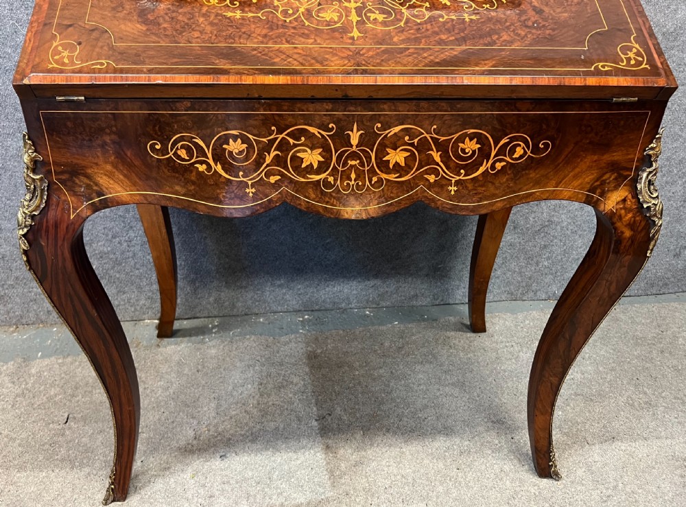 An antique Victorian inlaid walnut bureau de dame featuring a slant-front writing lid, floral marquetry, brass mounts, cabriole legs, and an upper cabinet with glazed doors. View XIII