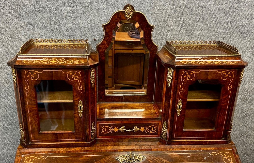 An antique Victorian inlaid walnut bureau de dame featuring a slant-front writing lid, floral marquetry, brass mounts, cabriole legs, and an upper cabinet with glazed doors. View XIV