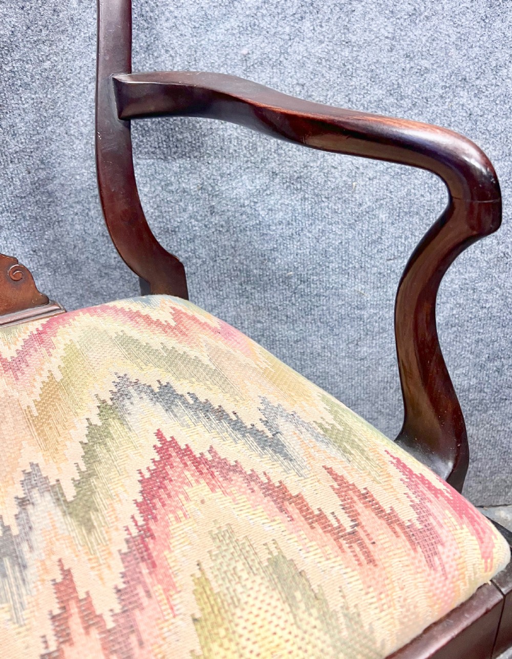 A dark mahogany George II style child armchair featuring a carved crest rail, vase-shaped back splat, shaped armrests, cabriole legs with pad feet, and a flame-stitch patterned seat. View V