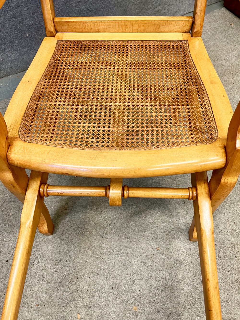 An antique French First World War campaign invalid chair constructed from light wood with woven cane panels and extending transport handles. View IV