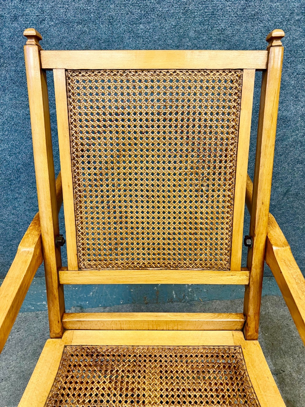 An antique French First World War campaign invalid chair constructed from light wood with woven cane panels and extending transport handles. View VII