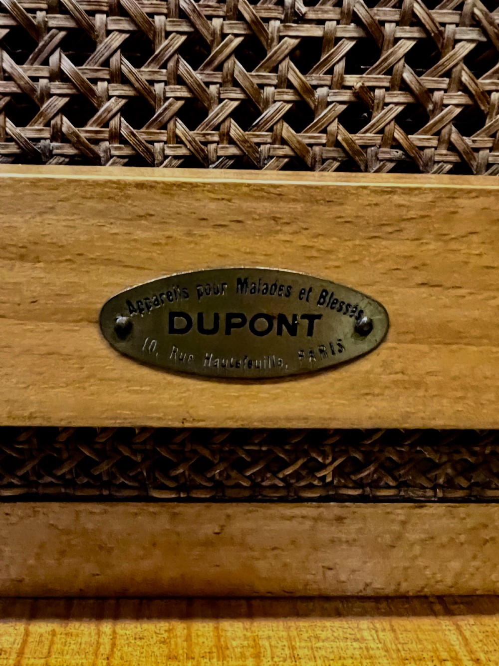 An antique French First World War campaign invalid chair constructed from light wood with woven cane panels and extending transport handles. View IX