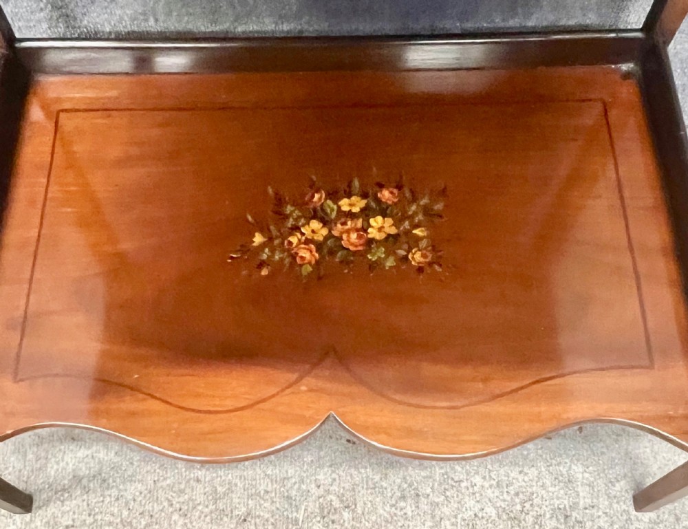 An Edwardian bonheur du jour desk crafted from polished dark wood, featuring a green leather writing surface, painted floral details, a upper superstructure with a painted portrait panel, small drawers, and a central glazed cabinet. View X