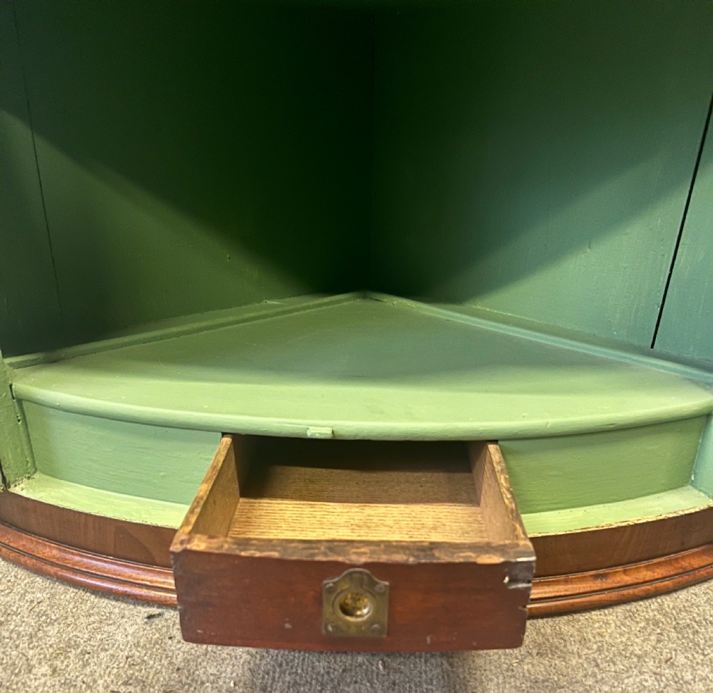 A George III mahogany bow-fronted hanging corner cabinet featuring double doors with fine stringing inlay and shield keyhole escutcheons. View VI