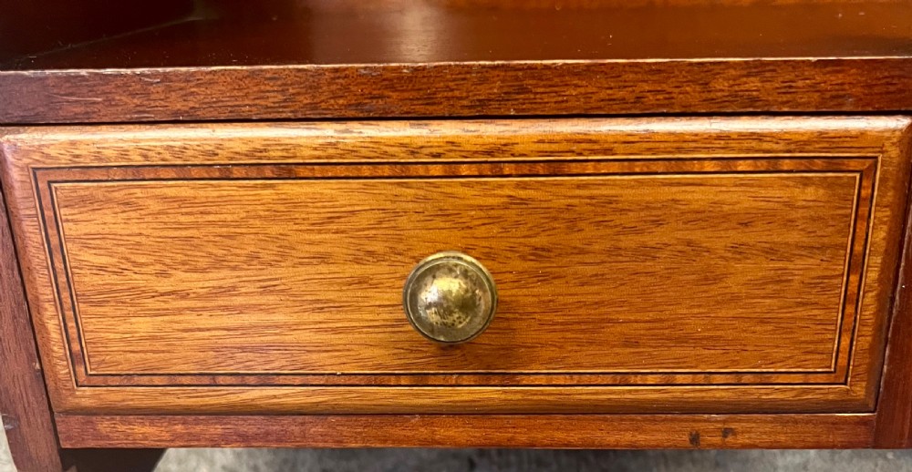 An Edwardian mahogany hanging wall shelf featuring turned spindle supports, fretwork side panels, and two small inlaid drawers with brass knobs. View V