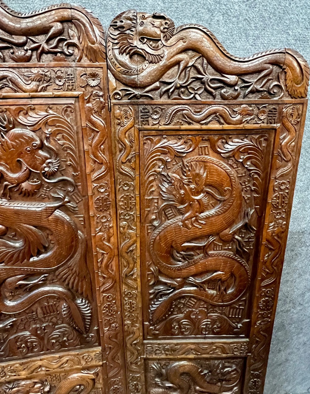 A four-panel carved hardwood folding room divider screen featuring relief dragon motifs and stepped top edges. View VIII