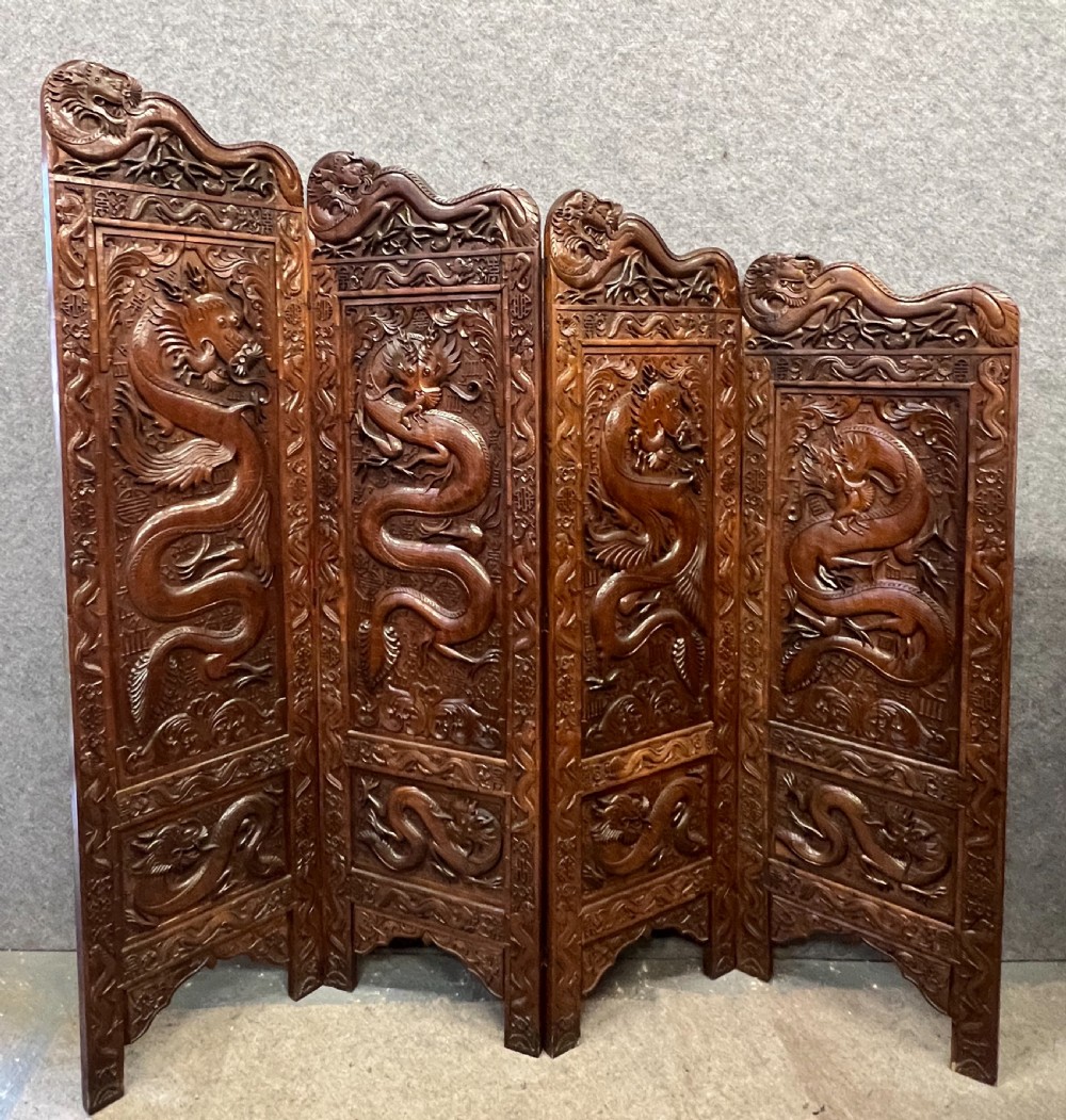 A four-panel carved hardwood folding room divider screen featuring relief dragon motifs and stepped top edges. View IX