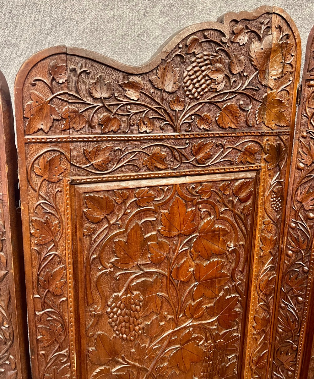 A four-panel carved hardwood folding room divider screen featuring relief dragon motifs and stepped top edges. View X