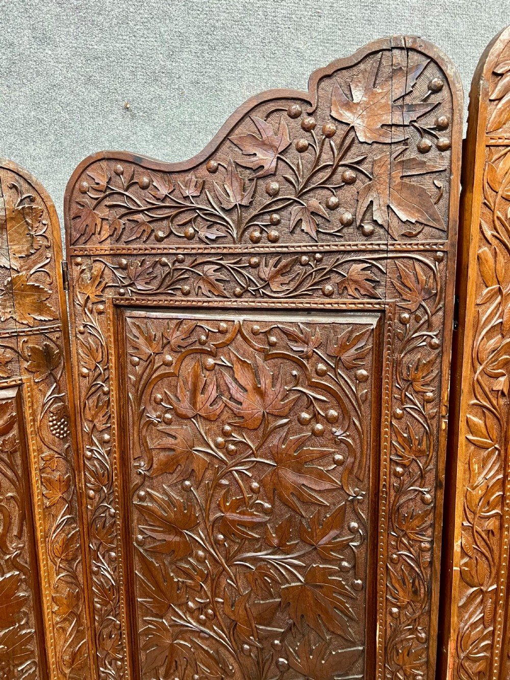 A four-panel carved hardwood folding room divider screen featuring relief dragon motifs and stepped top edges. View XI