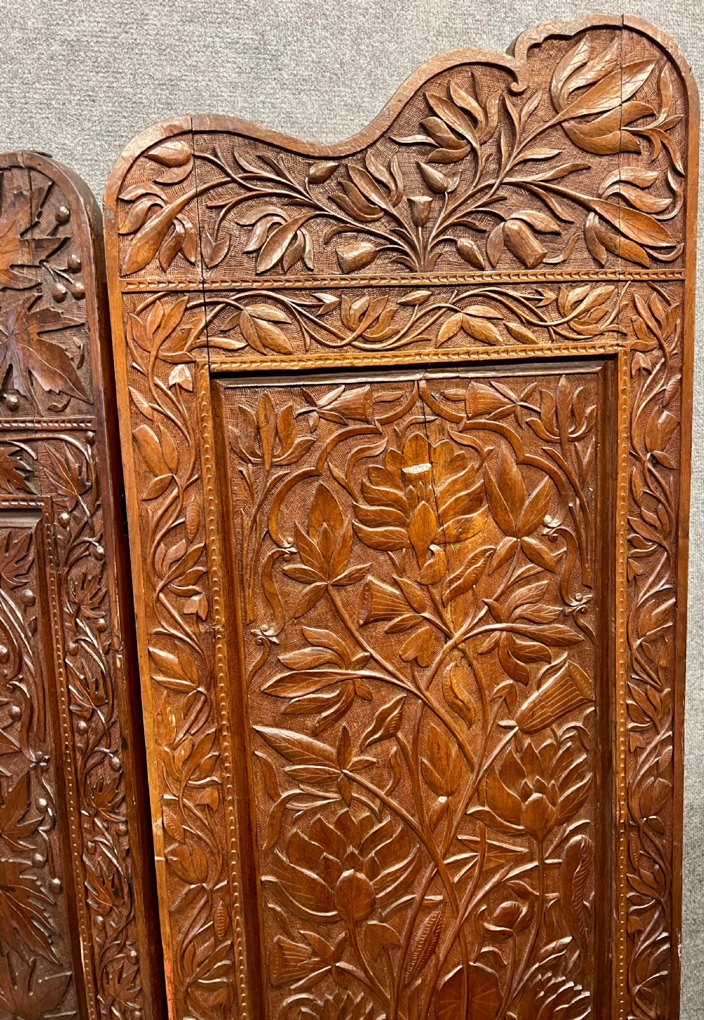 A four-panel carved hardwood folding room divider screen featuring relief dragon motifs and stepped top edges. View XII