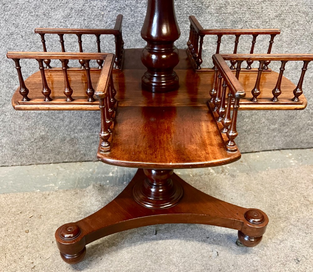 A circular mahogany revolving book mill table featuring a central turned column, four spindled book compartments, and a quadruped base. View IV
