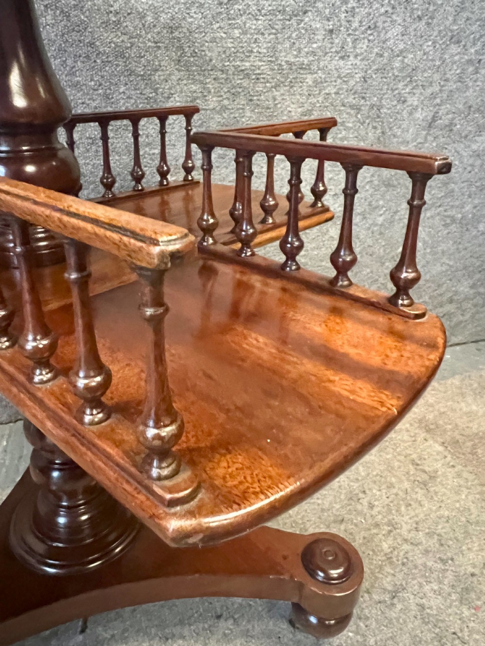 A circular mahogany revolving book mill table featuring a central turned column, four spindled book compartments, and a quadruped base. View VI