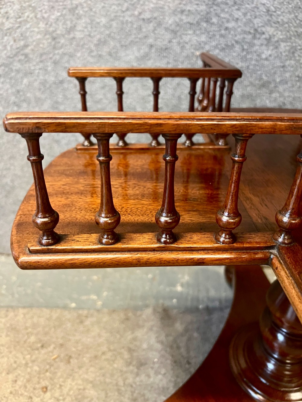 A circular mahogany revolving book mill table featuring a central turned column, four spindled book compartments, and a quadruped base. View VII