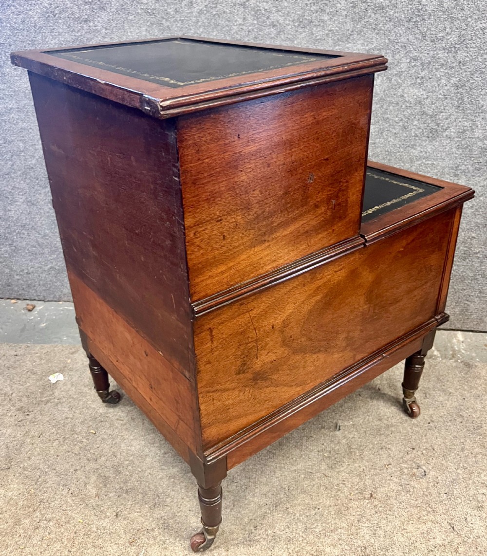 A Regency mahogany two-tier library step featuring dark leather inserts with gilt tooling, raised on turned legs with brass castors. View III