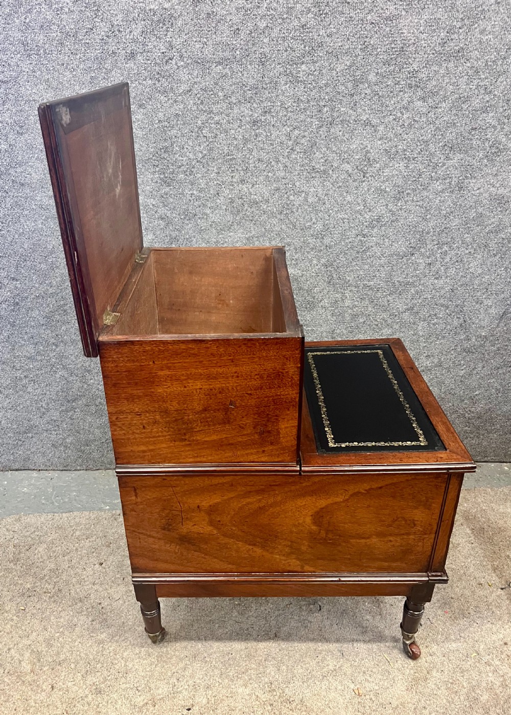 A Regency mahogany two-tier library step featuring dark leather inserts with gilt tooling, raised on turned legs with brass castors. View V