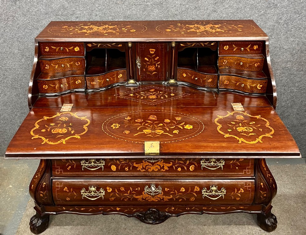 An antique Dutch marquetry writing bureau crafted from mahogany with detailed floral wood inlays, brass drop handles, and claw feet. View II