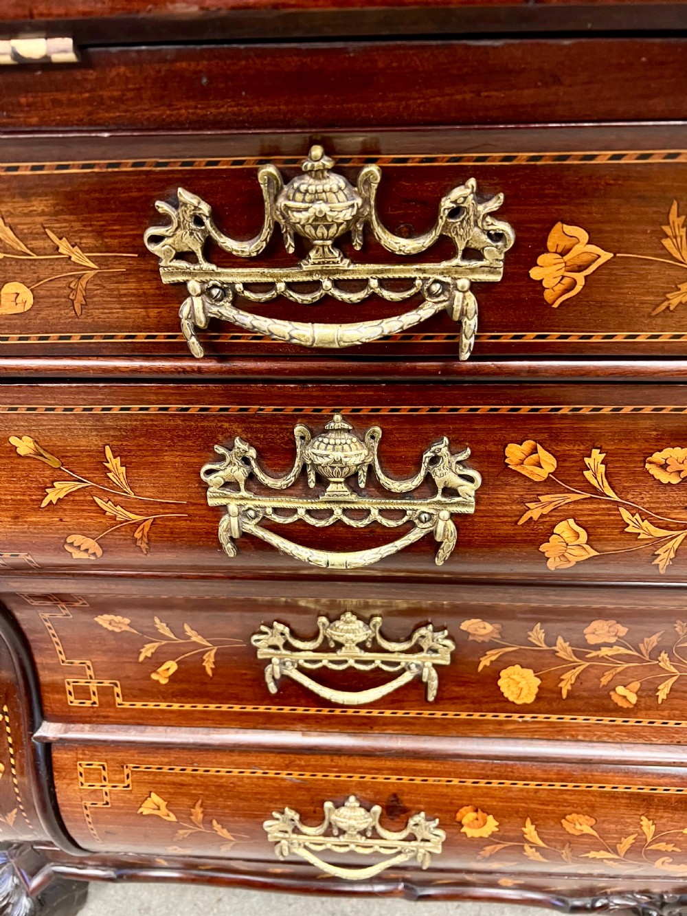 An antique Dutch marquetry writing bureau crafted from mahogany with detailed floral wood inlays, brass drop handles, and claw feet. View VII